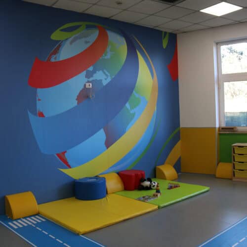 Progettazione scuola a Roma aula didattica bambini con murale colorato e arredi educativi