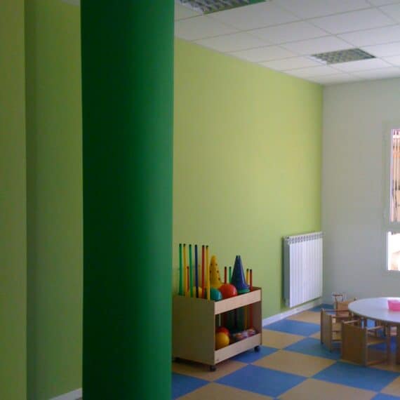 Interno asilo nido Roma con colonna colorata e area gioco